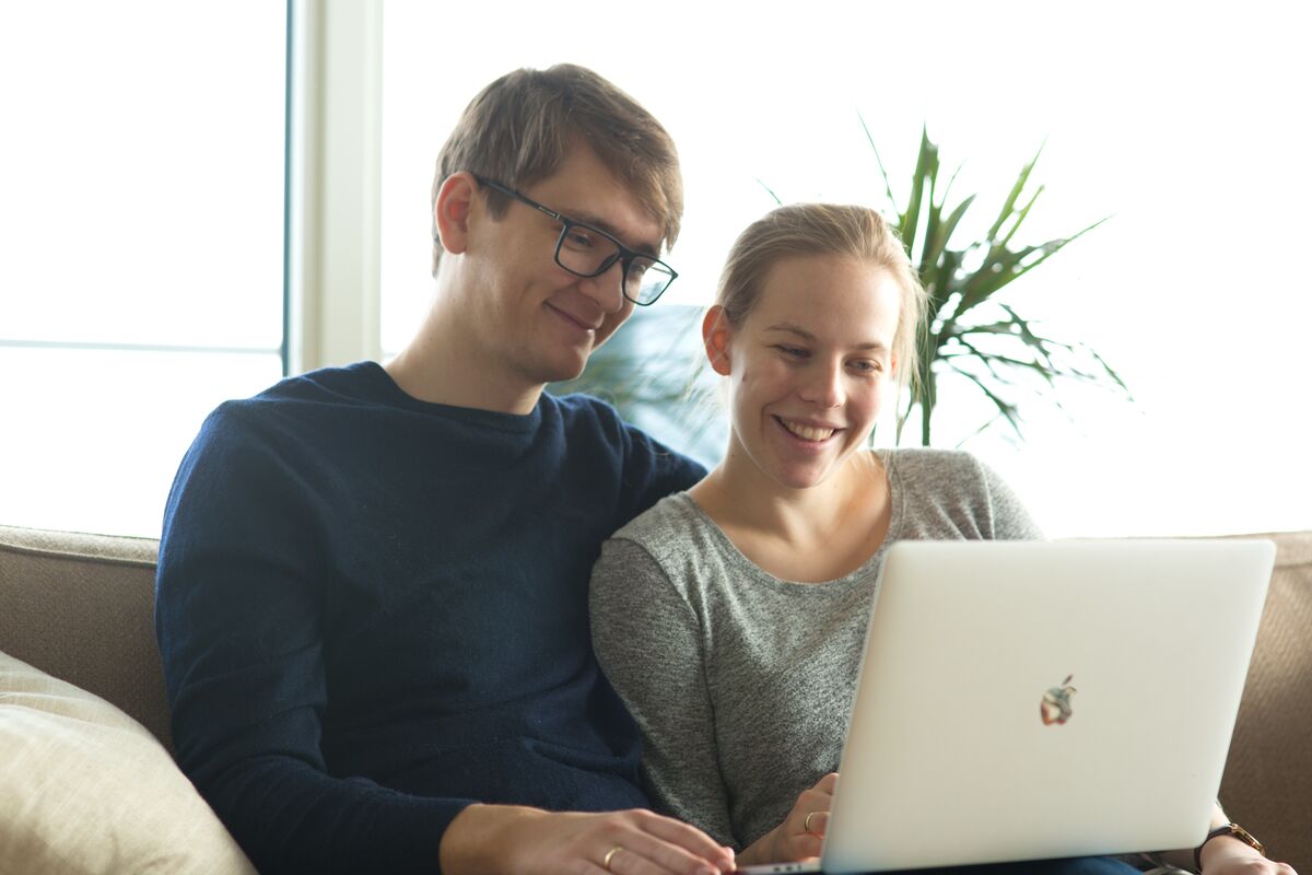 A couple, man and woman, looking at a computer together.