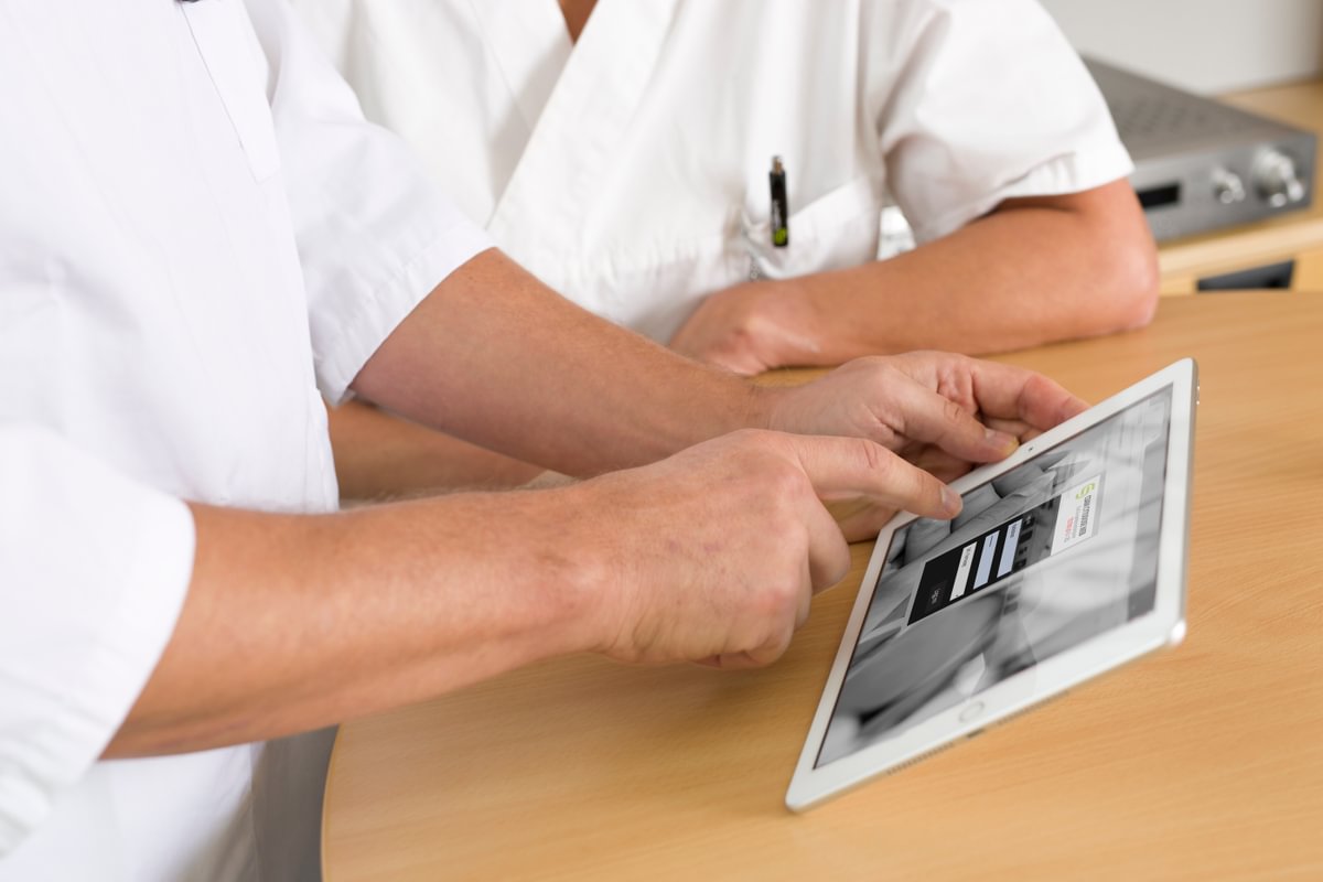 Two clinicians using medication management system on an iPad